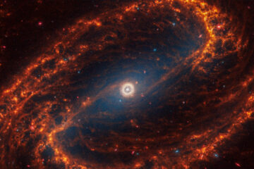 An image of the face-on barred spiral galaxy NGC 1300, showcasing its striking spiral arms radiating from a bright central bar structure. The intricate patterns of stars, gas, and dust create a stunning visual representation of the galaxy's dynamic and complex structure, set against the vast backdrop of space.